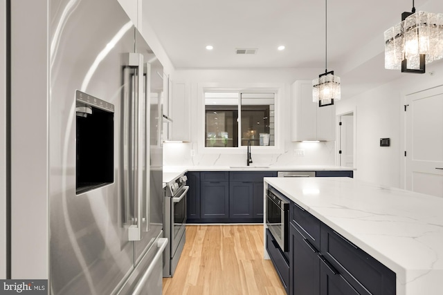 1251 Morse St NE Unit Ph3, Washington, DC 20002 - kitchen with visible vents, appliances with stainless steel finishes, light wood-type flooring, a sink, and light stone counters