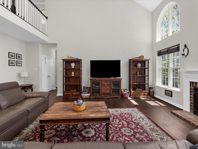 8283 Waterford Mill Ct, Pasadena, MD 21122 - living room featuring baseboards, a brick fireplace, a high ceiling, and wood finished floors