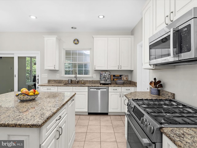 8283 Waterford Mill Ct, Pasadena, MD 21122 - kitchen with light tile patterned flooring, light stone counters, a sink, stainless steel appliances, and white cabinetry