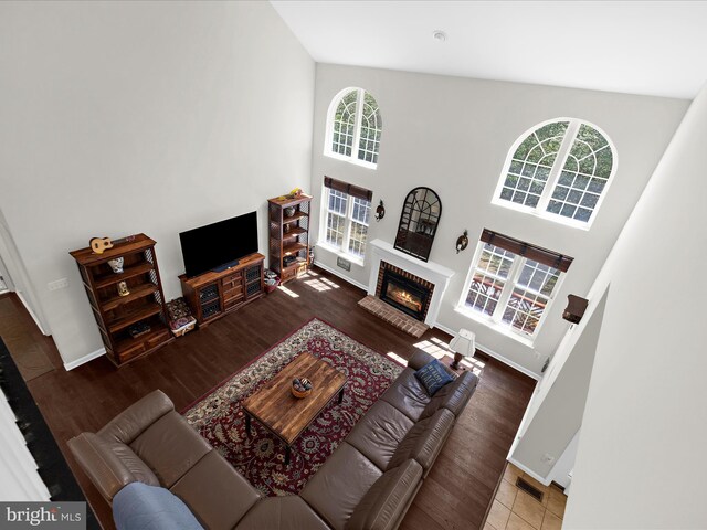8283 Waterford Mill Ct, Pasadena, MD 21122 - living area with visible vents, a brick fireplace, wood finished floors, baseboards, and a high ceiling