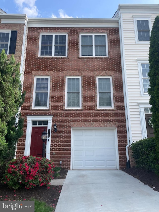 view of property with concrete driveway, brick siding, and a garage
