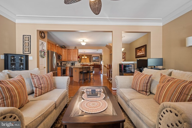 living room with crown molding, an inviting chandelier, and wood finished floors