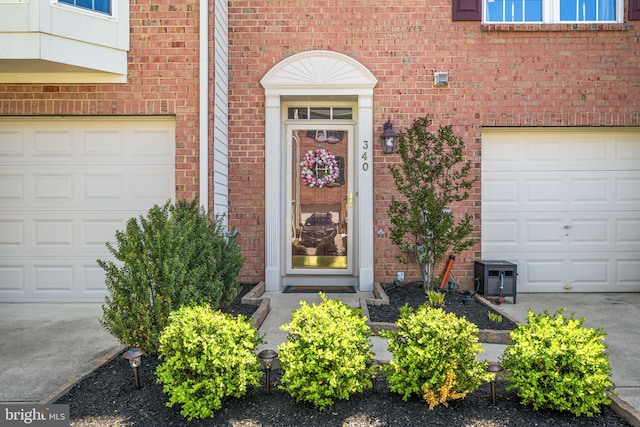 property entrance with brick siding and an attached garage