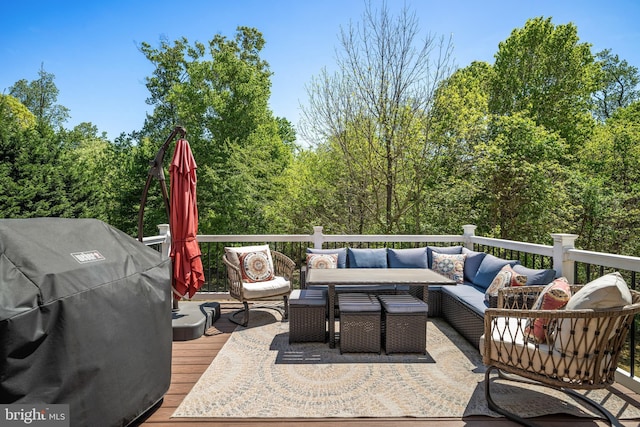 wooden terrace with an outdoor living space and area for grilling