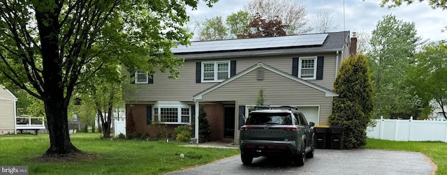 3219 Sunset Ave, Norristown, PA 19403 - view of front of home with asphalt driveway, roof mounted solar panels, a chimney, and brick siding