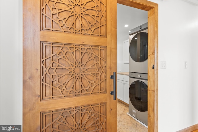 clothes washing area with laundry area, stacked washer and clothes dryer, and recessed lighting