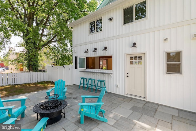 view of patio / terrace with fence, outdoor dry bar, and an outdoor fire pit