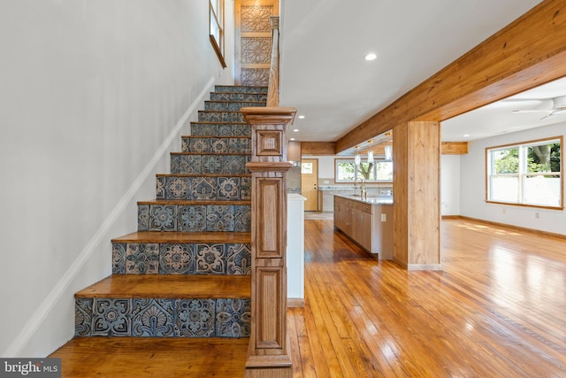 staircase with wood-type flooring, recessed lighting, and a healthy amount of sunlight