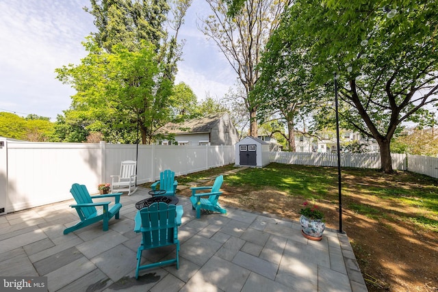 view of patio / terrace featuring an outbuilding, a fenced backyard, and a storage unit