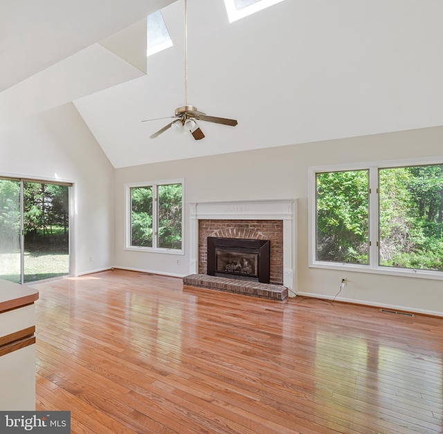 14640 Balsam Ct, Issue, MD 20645 - unfurnished living room with high vaulted ceiling, a skylight, a brick fireplace, ceiling fan, and light wood-style floors