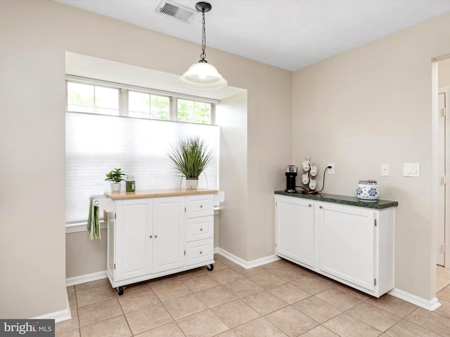 bar with pendant lighting, baseboards, light tile patterned flooring, and visible vents
