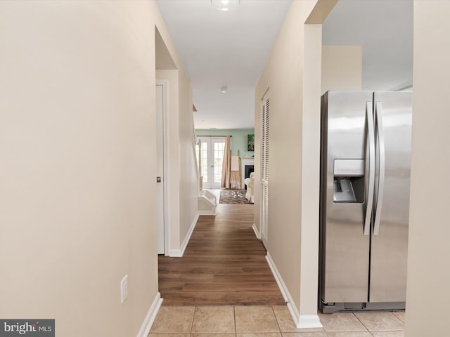 corridor with baseboards and light tile patterned flooring