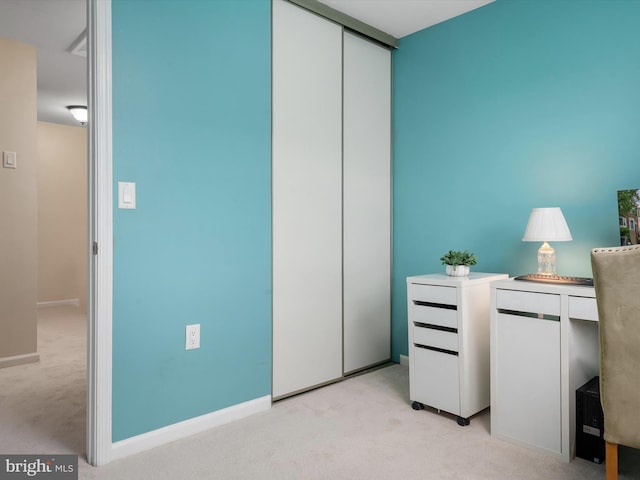 office with baseboards and light carpet