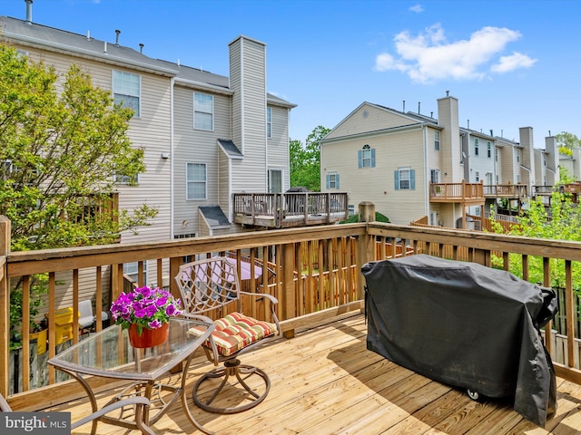 deck with a residential view and a grill