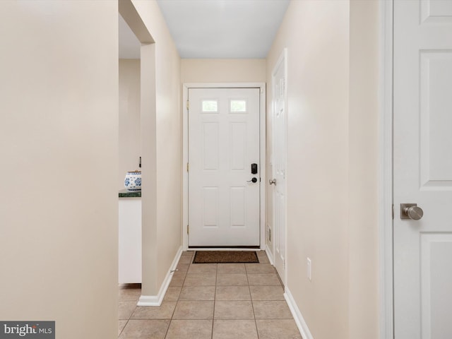 entryway featuring baseboards and light tile patterned flooring