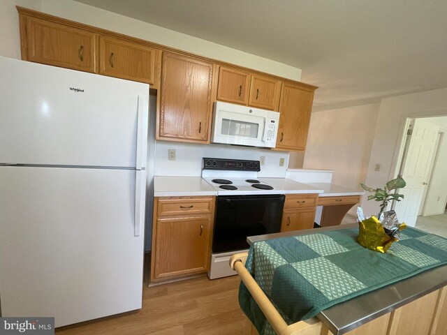 kitchen with light countertops, brown cabinets, light wood-type flooring, and white appliances