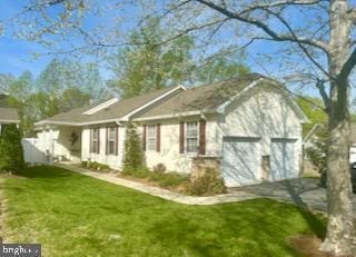 rear view of property featuring a yard and a garage