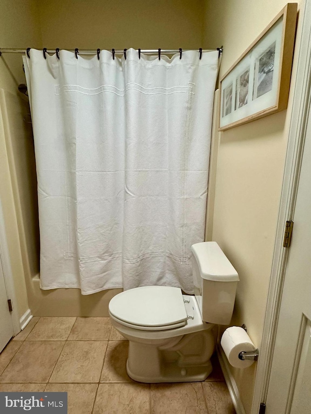 full bath featuring tile patterned flooring, shower / tub combo with curtain, and toilet