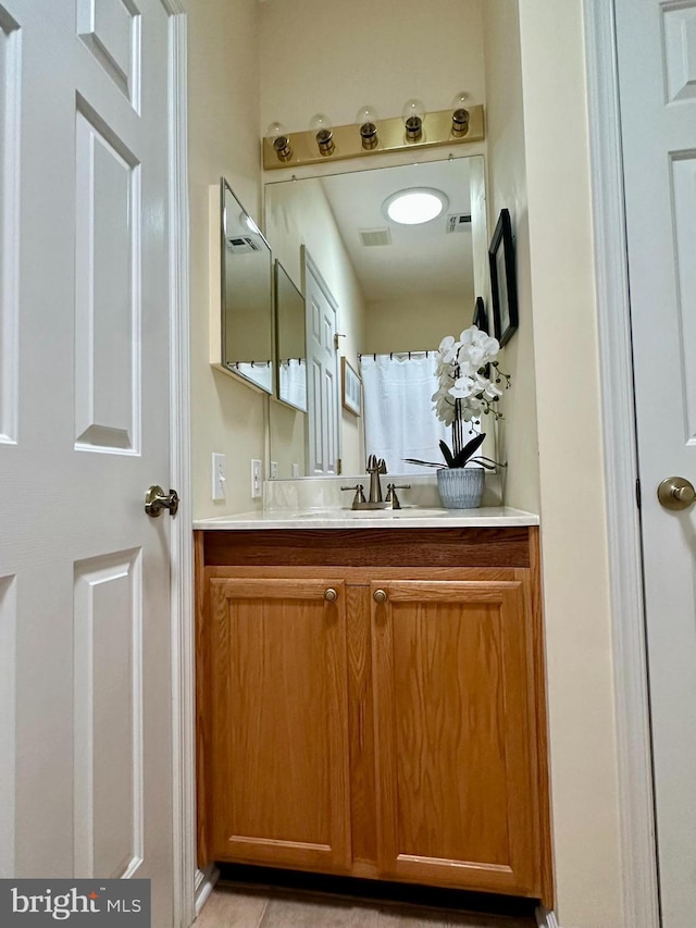 bathroom featuring visible vents, tile patterned floors, and vanity