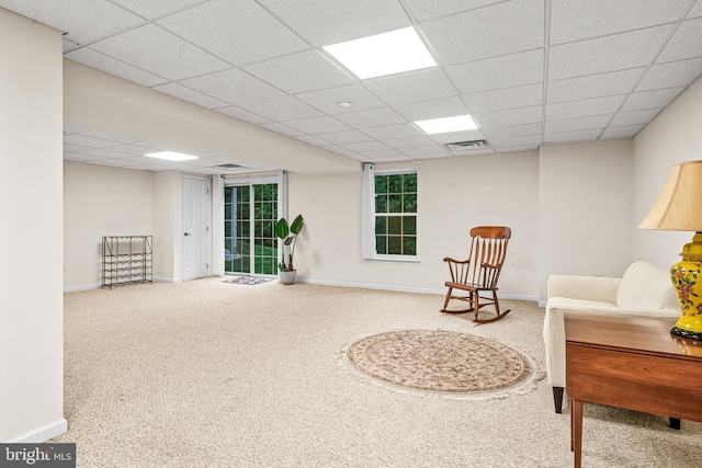 living area with baseboards, a drop ceiling, carpet flooring, and visible vents