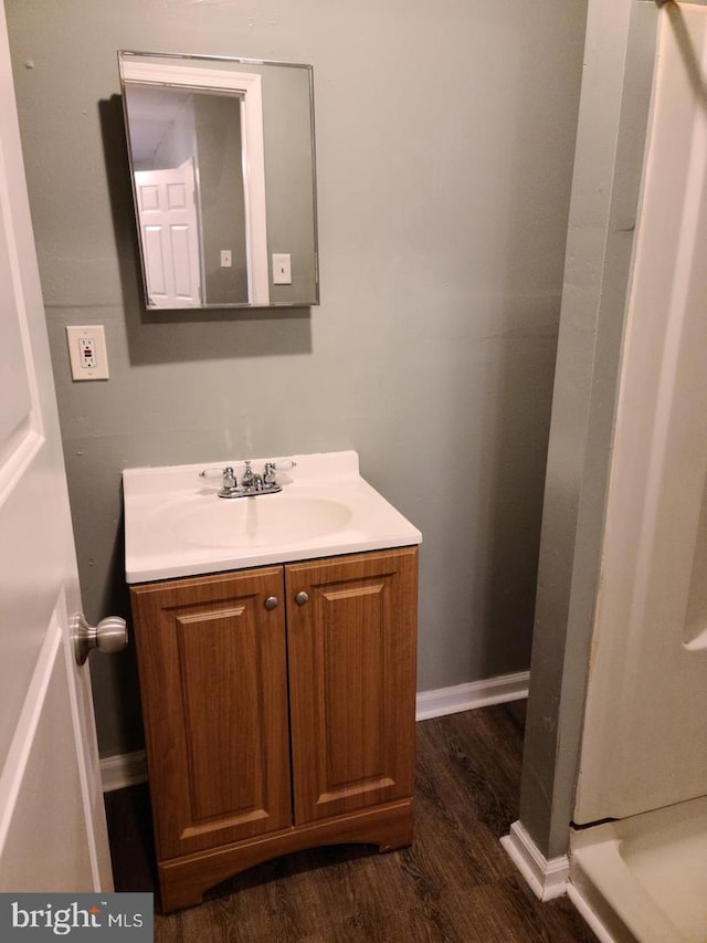 bathroom with vanity, baseboards, and wood finished floors