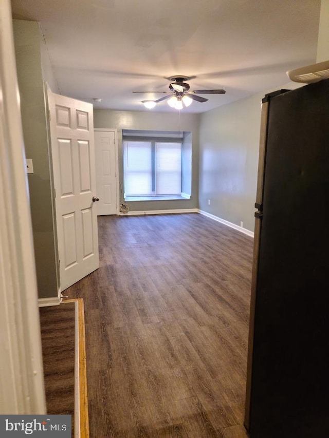 unfurnished room featuring dark wood-type flooring, baseboards, and ceiling fan