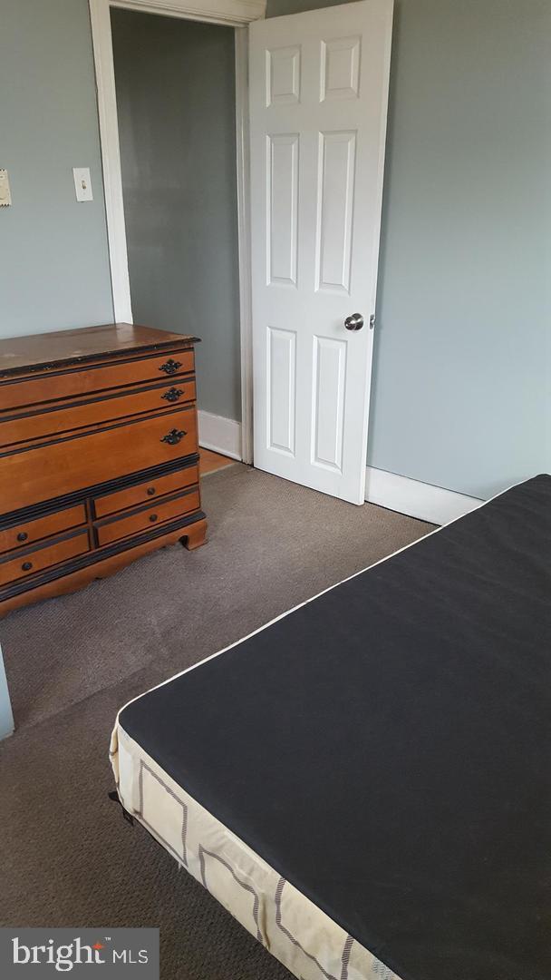 bedroom featuring baseboards and dark colored carpet