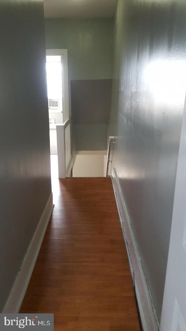 hallway featuring wood finished floors and an upstairs landing