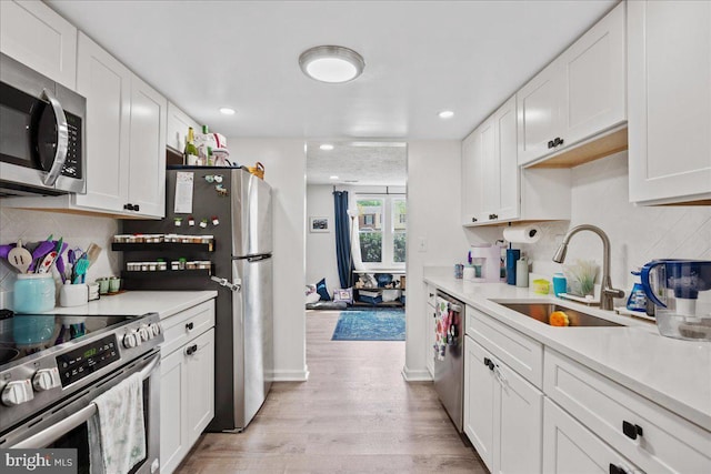 1653 Forest Park, District Heights, MD 20747 - kitchen with light wood-type flooring, a sink, white cabinetry, and appliances with stainless steel finishes
