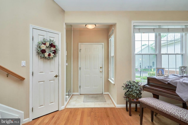 foyer with baseboards, light wood-style floors, and plenty of natural light