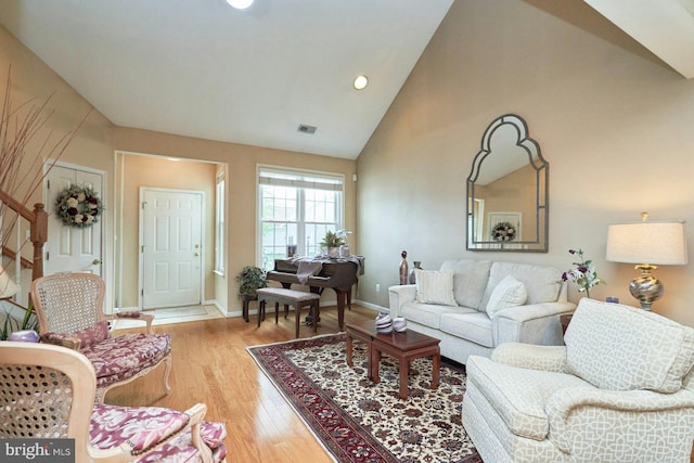 living room featuring wood finished floors, high vaulted ceiling, visible vents, baseboards, and recessed lighting