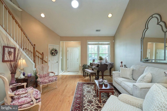 living room featuring stairs, recessed lighting, light wood finished floors, and visible vents
