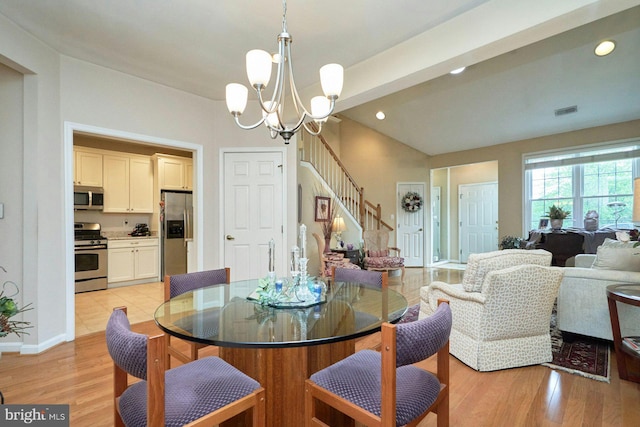 dining space with recessed lighting, light wood finished floors, an inviting chandelier, visible vents, and stairway