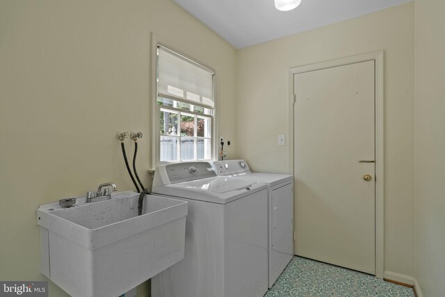 laundry area with laundry area, a sink, and washer and clothes dryer