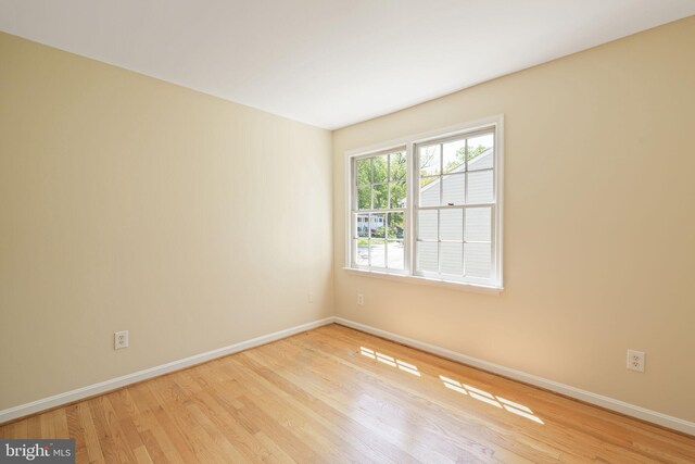 spare room featuring baseboards and wood finished floors