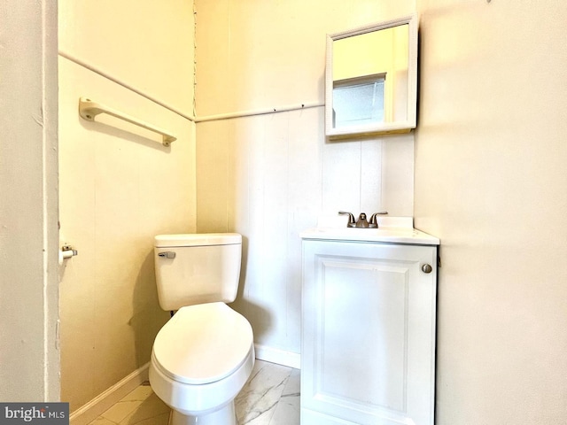 bathroom with toilet, baseboards, marble finish floor, and vanity