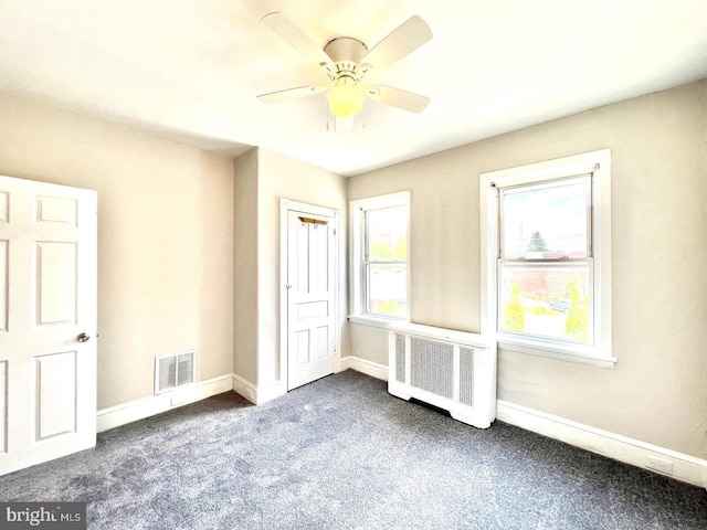 unfurnished bedroom featuring visible vents, a ceiling fan, baseboards, and dark colored carpet