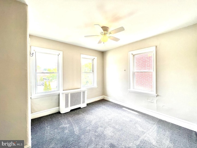 carpeted spare room featuring a ceiling fan, baseboards, and radiator heating unit
