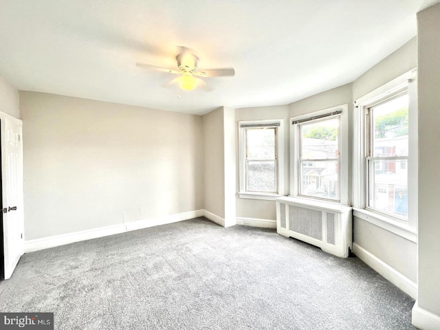 carpeted empty room with baseboards and a ceiling fan