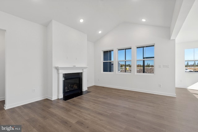 unfurnished living room featuring a fireplace with flush hearth, dark wood finished floors, baseboards, lofted ceiling, and recessed lighting