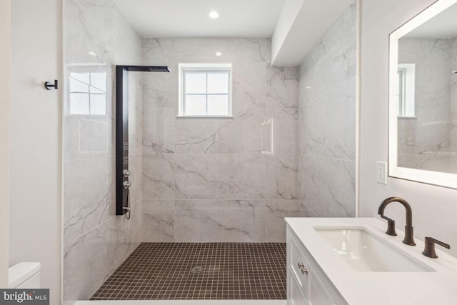 full bath featuring vanity, a marble finish shower, and toilet