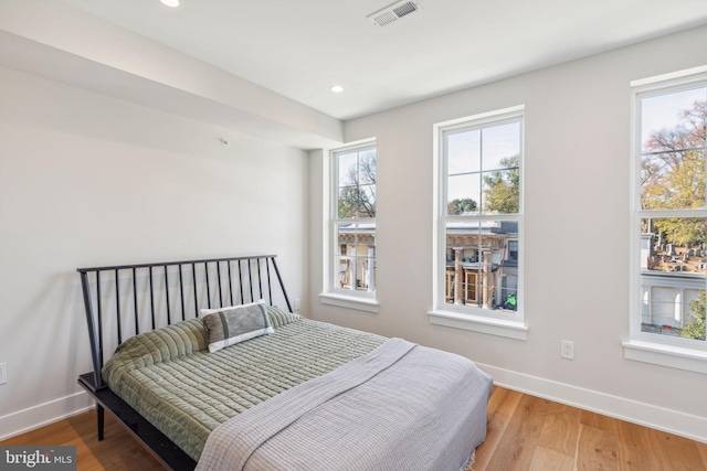 bedroom with recessed lighting, baseboards, visible vents, and wood finished floors