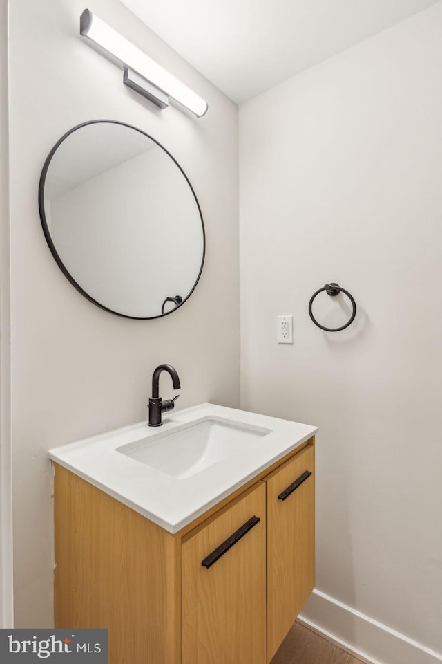 bathroom with vanity, baseboards, and wood finished floors