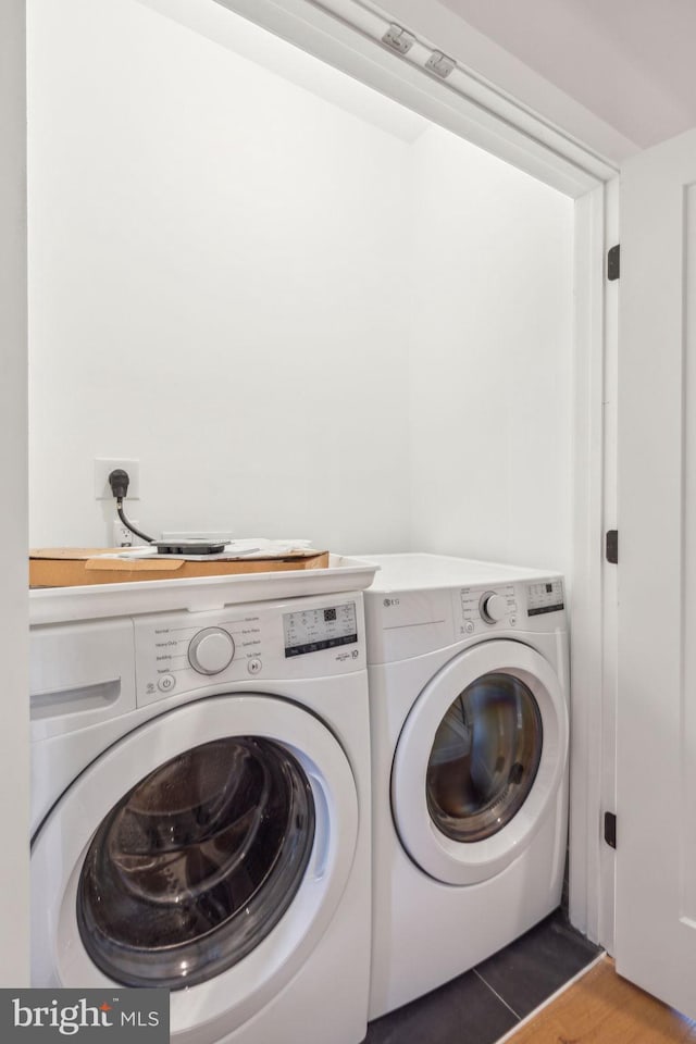 clothes washing area featuring laundry area and washer and clothes dryer