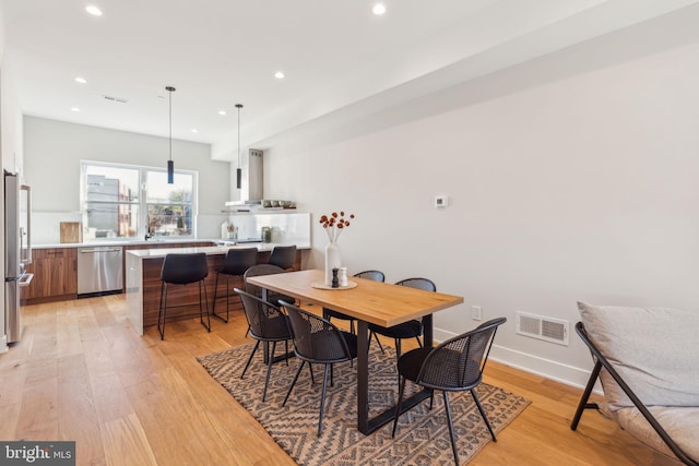 dining space with recessed lighting, visible vents, and light wood finished floors