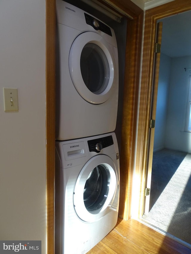 clothes washing area featuring stacked washer / drying machine and laundry area