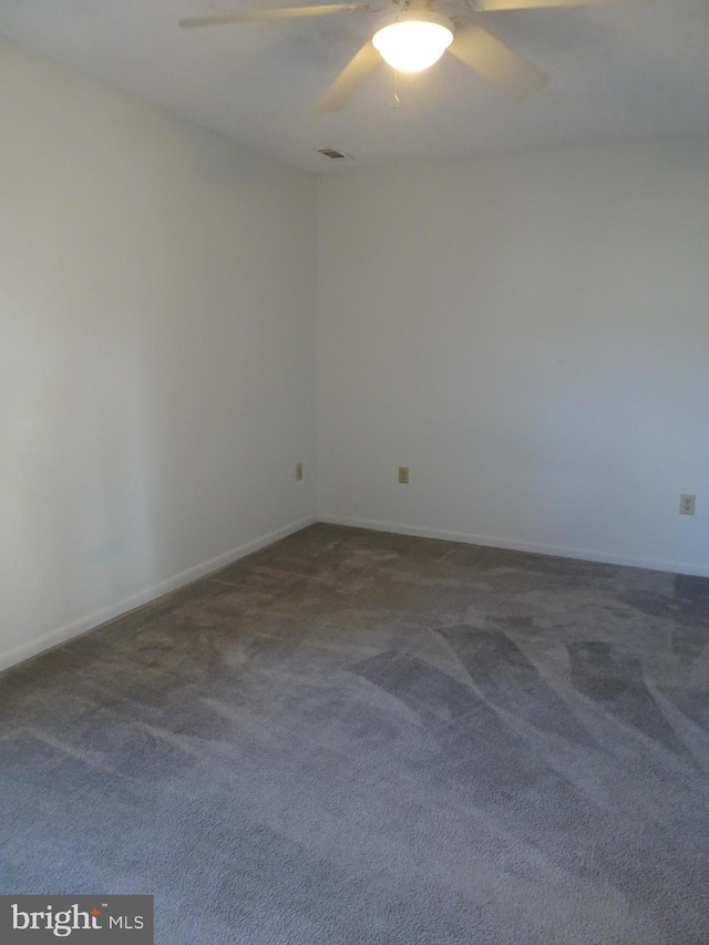 carpeted spare room with baseboards and a ceiling fan