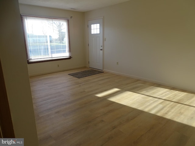 foyer with baseboards and wood finished floors