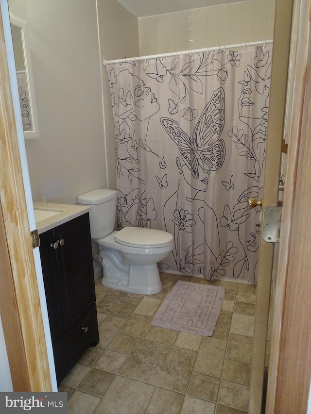 full bath featuring vanity, a shower with shower curtain, and toilet