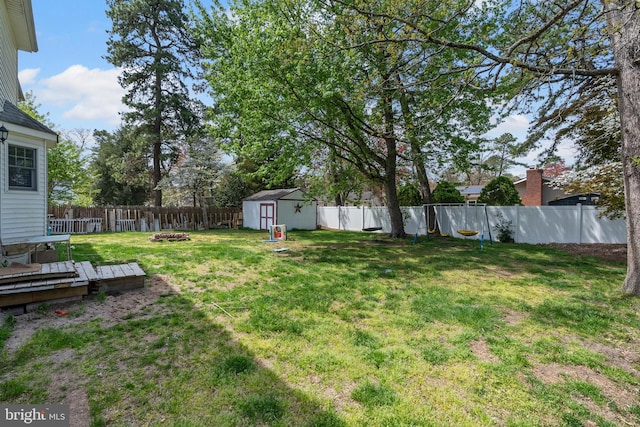 13 Maricopa Trl, Browns Mills, NJ 08015 - view of yard featuring a deck, an outbuilding, a fenced backyard, an outdoor fire pit, and a storage unit
